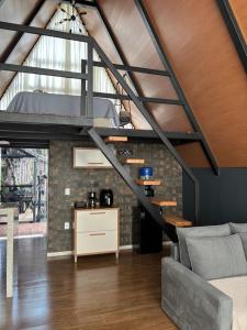 a loft conversion with a staircase and a living room at Chalé Aconchego in Caparaó Velho +14 photos