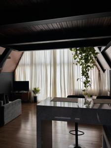 a living room with a table and a large window at Chalé Aconchego in Caparaó Velho