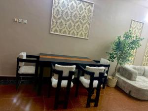 a dining room table with chairs and a painting on the wall at Alpha serenity in Mwanza