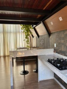 a kitchen with a counter top and a stove at Chalé Aconchego in Caparaó Velho