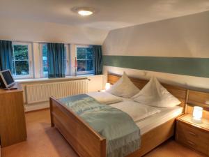 a bedroom with a bed and two windows at NOEL Hotel-Restaurant in Seevetal