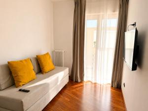 a living room with a couch with yellow pillows at Del Console Apartment 2 - Near Bari Airport & Station in Modugno