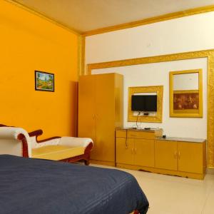 a hotel room with a bed and a tv at Adory homes inn in Kelambākkam