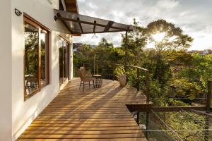 a wooden deck with a table and chairs on a house at Refúgio das Serras in Cunha