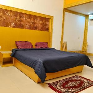 a bedroom with a large bed with a blue blanket at Adory homes inn in Kelambākkam