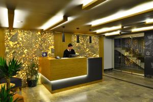 アランヤにあるPrince Apart & Hotelのロビーのカウンターに座る男