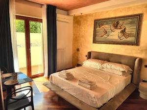 a bedroom with a bed and a table and a window at Del Console Garden Suite - Near Bari Airport & Station in Modugno