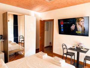 a living room with a tv on a wall at Del Console Garden Suite - Near Bari Airport & Station in Modugno
