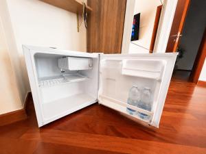 an open refrigerator with two bottles of water in it at Del Console Garden Suite - Near Bari Airport & Station in Modugno