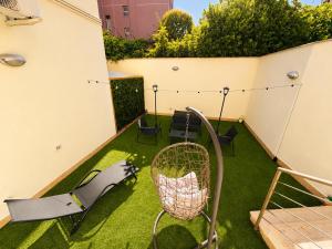 a small backyard with a swing and grass at Del Console Garden Suite - Near Bari Airport & Station in Modugno