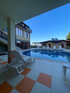 a swimming pool with a chair and a table at Complex Terazini in Byala