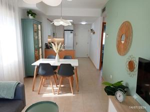 a dining room and living room with a table and chairs at ILDA MENTa in Miami Platja