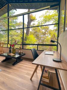 an office with a table and chairs and a large window at Minca Ecohabs Hotel in Minca