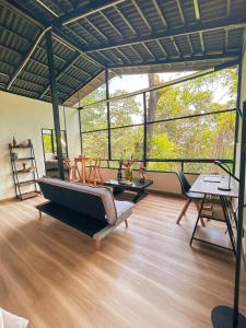 a room with a couch and tables and windows at Minca Ecohabs Hotel in Minca