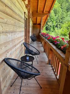 a porch with chairs and flowers on a cabin at Berglsteinersee 712er Lounge in Breitenbach am Inn +11 photos