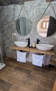 a bathroom with two sinks and a mirror at El rincon de Fausto in Mudrián +7 photos
