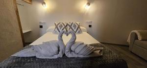 two towelsrendered to look like swans on a bed at El rincon de Fausto in Mudrián