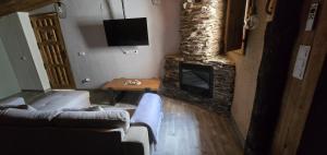 a living room with a couch and a fireplace at El rincon de Fausto in Mudrián