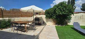 a patio with a table and an umbrella at El rincon de Fausto in Mudrián