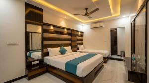 a bedroom with two beds and a ceiling at Hotel Shree Vrindavan in Nāthdwāra
