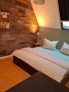 a bedroom with two beds and a wooden wall at Ferienwohnungen beim Weilerbauer in Gerstetten