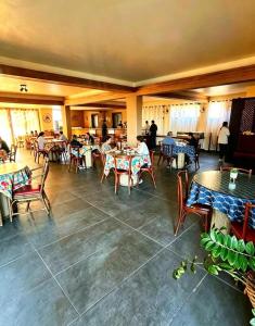 a restaurant with tables and chairs and people sitting at tables at Beachfront suite right on the sand in Cabo Frio