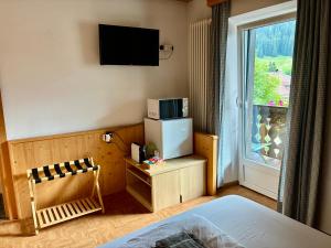 a room with a bed and a tv and a window at La Perla di Pera in Pera