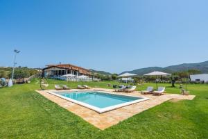 a swimming pool in a yard with chairs and a house at Hotel Marina in Badesi