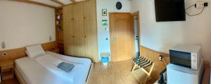 a bedroom with a bed and a flat screen tv at La Perla di Pera in Pera +8 photos