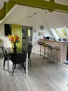 a dining room with a glass table and chairs at L'Ecrin Normand appartement avec jardin comportant 2 lits 2 places et 1 lit 1 place in Cambremer