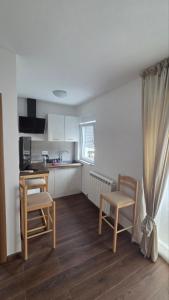 a kitchen with two chairs and a table and a counter at VIP Durmitor in Žabljak