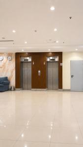 a lobby with four doors and a white floor at براديس لاند نبراس الهدئ in Mecca +32 photos