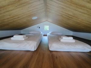 two twin beds in a room with a wooden ceiling at Domki nad Grabią in Rokitnica