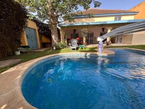 a swimming pool in front of a house at Villa Reine Saly in Saly Portudal