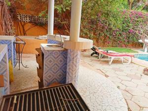 a patio with a heater and a table and a bench at Villa Reine Saly in Saly Portudal