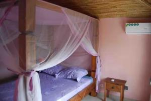 a small bed with a canopy in a room at Villa Reine Saly in Saly Portudal +19 photos