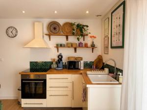 a small kitchen with a sink and a microwave at Au Canon - Parking gratuit - Bords de Loire in Orléans