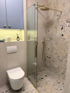 a bathroom with a toilet and a glass shower at Apartament Lake Mood Iława in Iława +8 photos