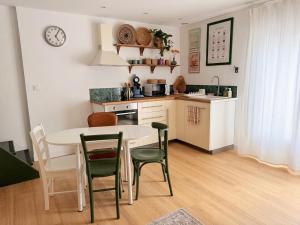 a kitchen with a table and chairs and a kitchen with a counter at Au Canon - Parking gratuit - Bords de Loire in Orléans +16 photos