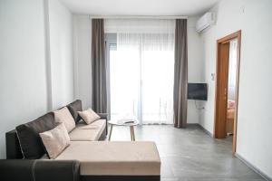 a living room with a couch and a large window at Apartman Amin&Amina in Ulcinj