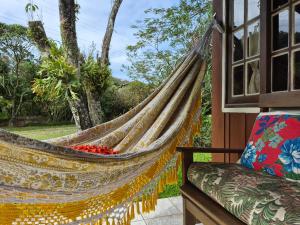 a hammock on the porch of a house at Cabanas Areias in Praia do Rosa +13 photos