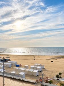 a beach with white boxes on the sand at De Zandkorrel - Amazing seaview in Wenduine