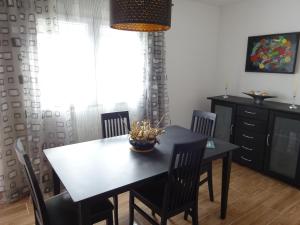 a dining room with a black table and chairs at Casa do Pinheiro in Louriceira