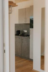 a kitchen with a counter and a refrigerator at Natururlaub by Klotz TINY HAUS d in Überlingen +9 photos