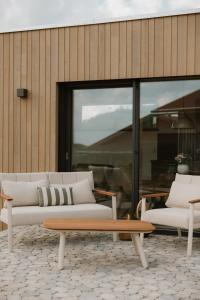 two white couches and a bench in front of a building at Natururlaub by Klotz TINY HAUS d in Überlingen