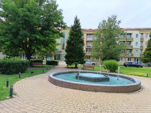 a fountain in a park in front of a building at alma713 apartman in Zalakaros