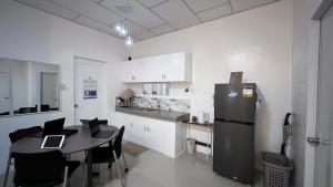 a kitchen and dining room with a table and a refrigerator at Thad Transient House - Gensan in General Santos