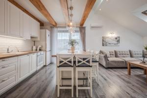 a kitchen and living room with white cabinets and a table at Gerika guest house in Palanga +148 photos