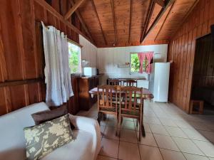 a living room with a table and a kitchen at Cabanas Areias in Praia do Rosa