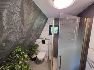 a bathroom with a toilet and plants in it at Api Chalet in Avrig